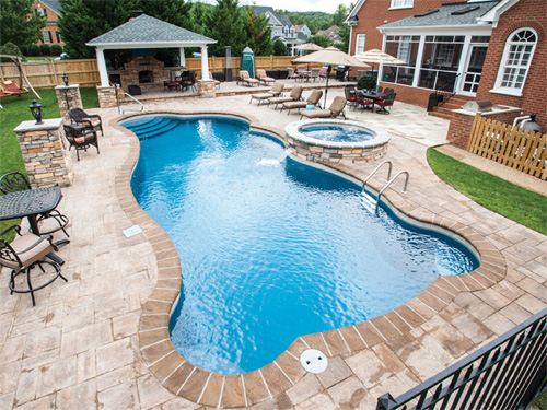 This 40' x 16' Synegry freeform pool from Trilogy features 3 separate swim out benches along with a beautiful set of entry stairs in the shallow end and a connected spa.